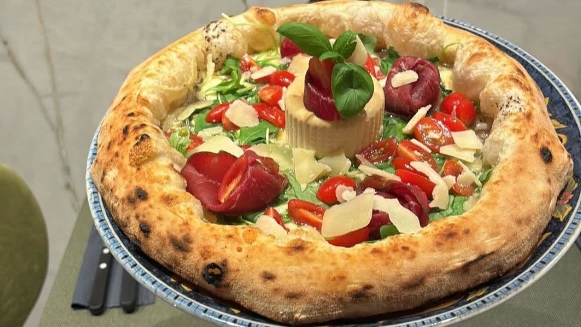 Pizza photographiée chez Amore, avec une croûte dorée et une garniture généreuse
